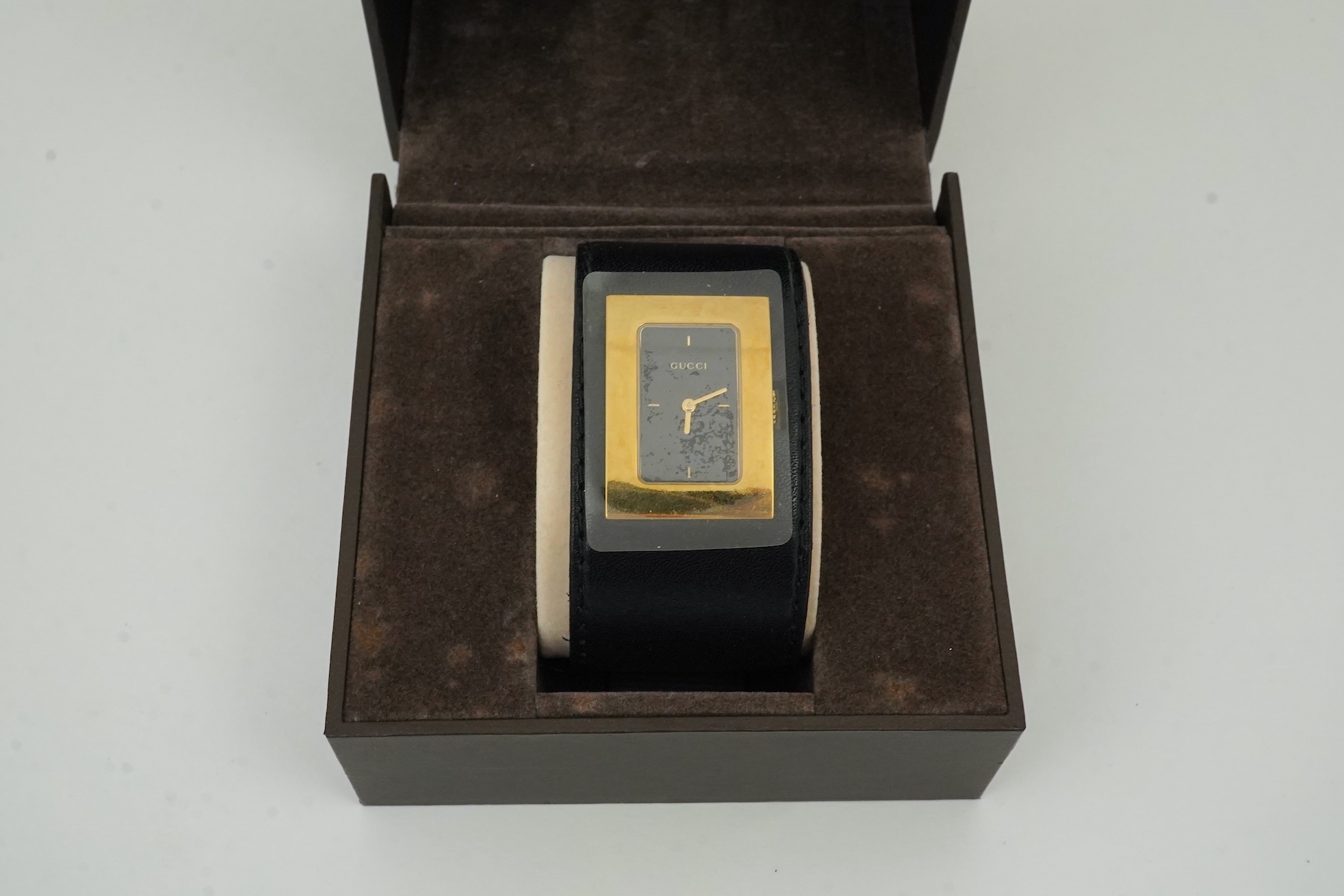 A lady's Gucci watch with wide leather strap, with box and papers.